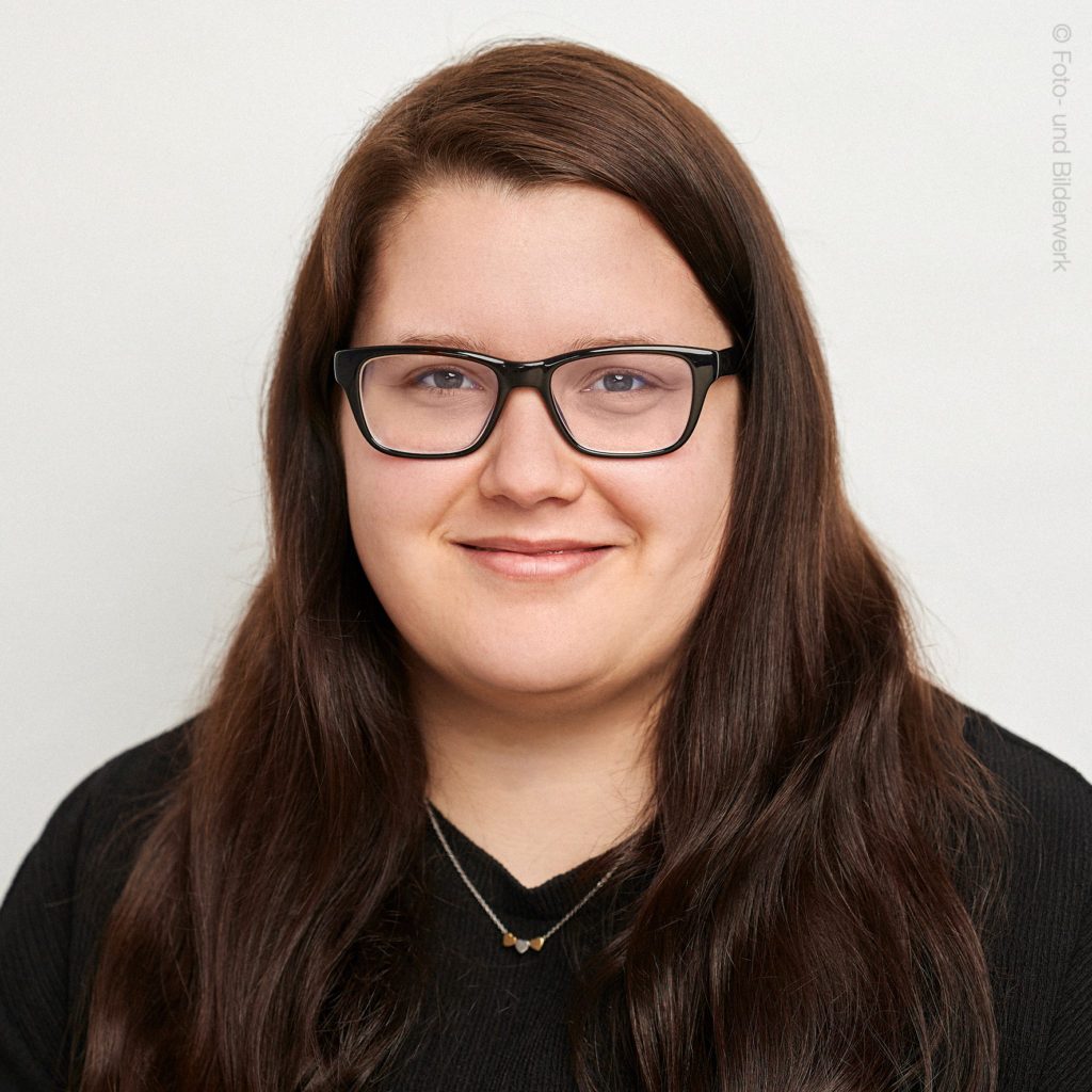 Person lächelt ruhig Kamera frontal Hintergrund neutral