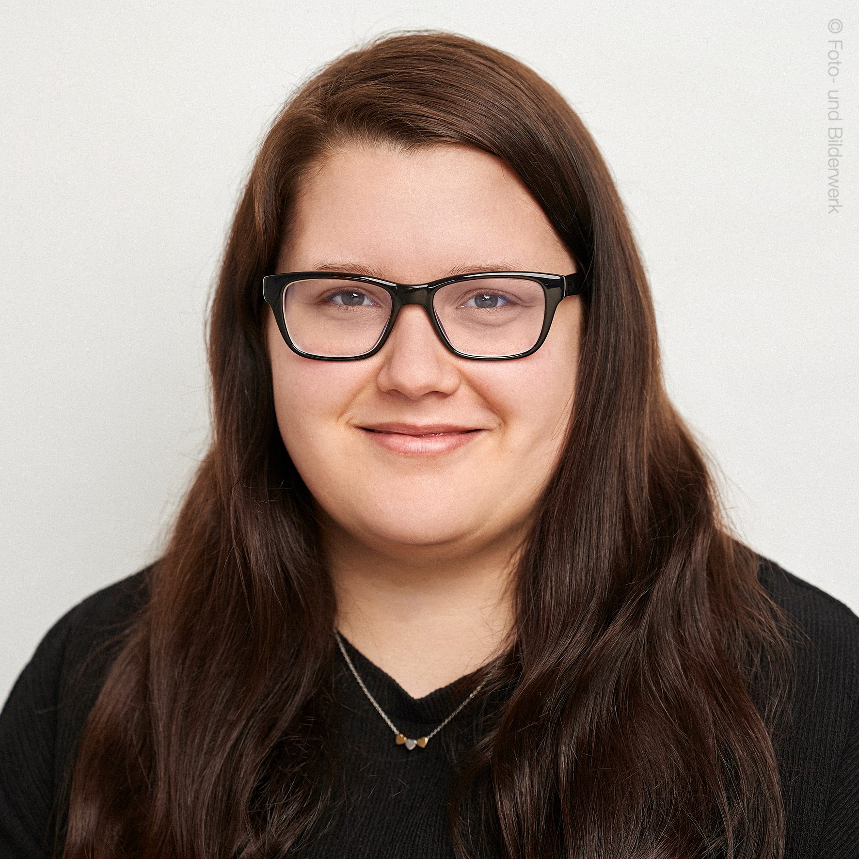 Person lächelt ruhig Kamera frontal Hintergrund neutral